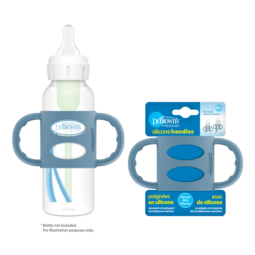 A clear baby bottle equipped with a blue Dr. Brown’s® Milestones™ Narrow Silicone Handle on each side is showcased, encouraging independent drinking skills, while the nearby packaging displays the brand "Dr. Brown's" in an eye-catching blue and white design.