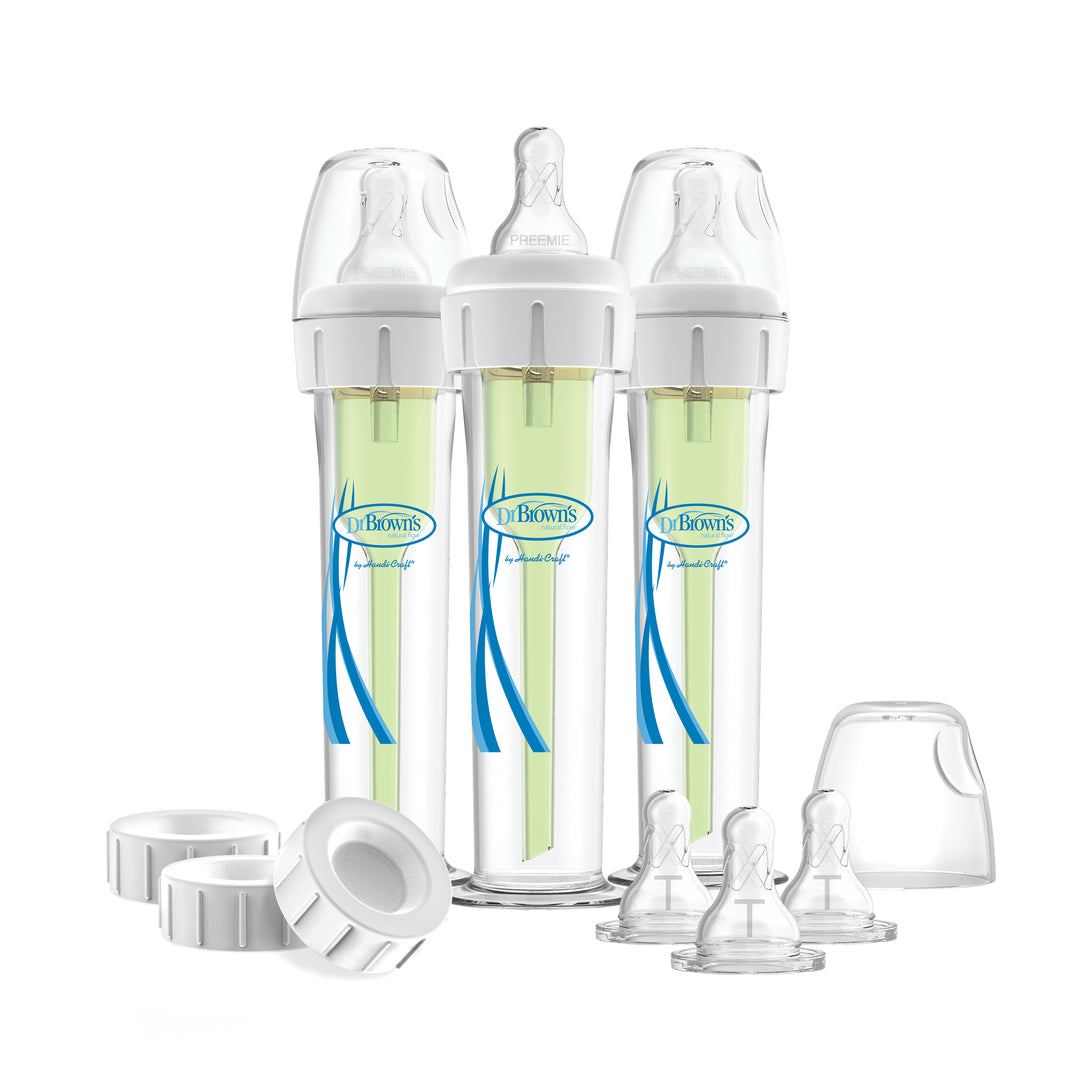 A set of three Dr. Brown's Accufeed Baby Bottles with Preemie Nipples (60cc), featuring green inserts and accompanied by extra bottle nipples, caps, and lids. These transparent bottles, displaying their labels and designs, are engineered to help reduce colic through a specialized venting system.