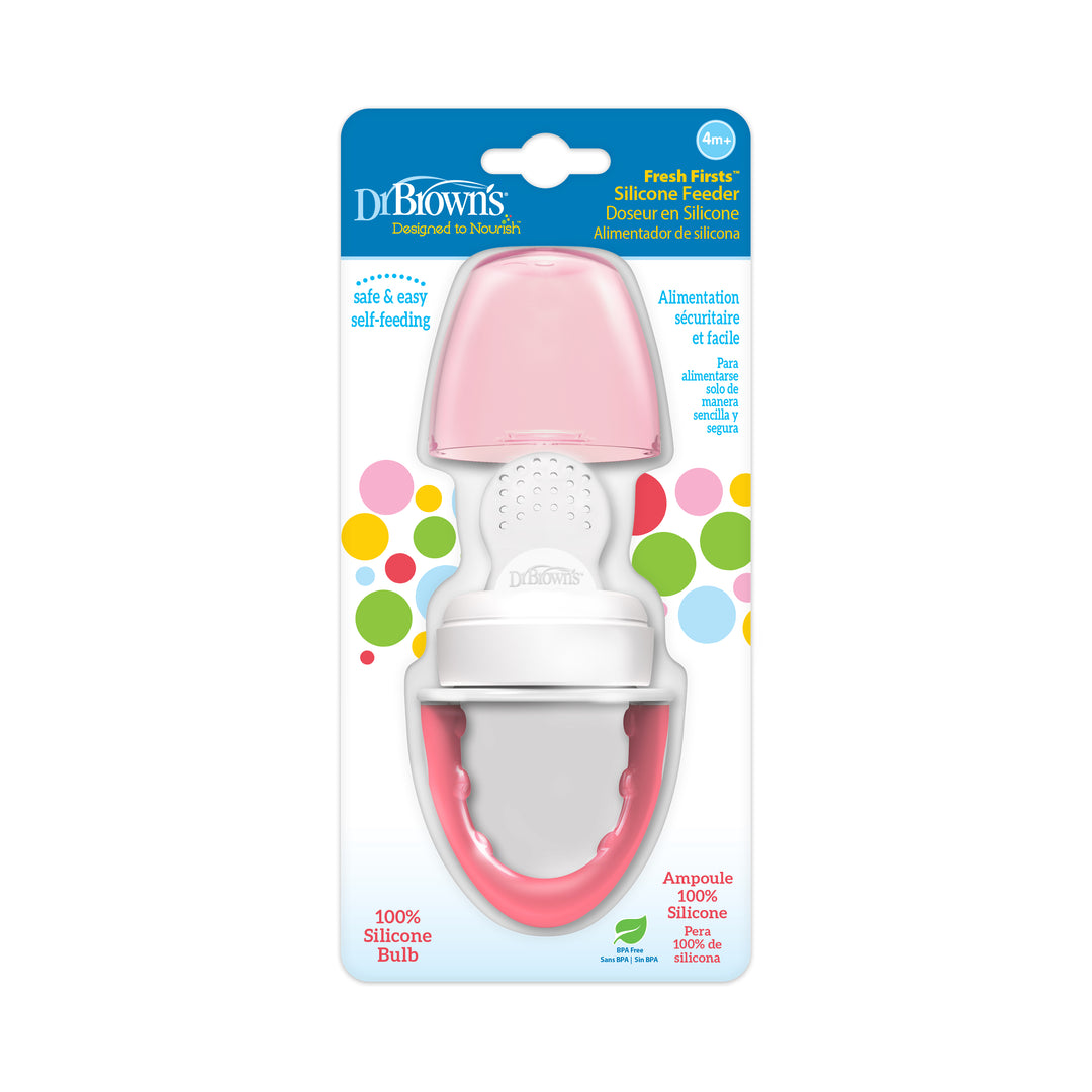 The packaging of Dr. Brown's™ Fresh Firsts™ Silicone Feeder highlights a pink and white silicone bulb, featuring a design that promotes safe and easy self-feeding for infants aged 6 months and older, all set against a colorful dotted background.