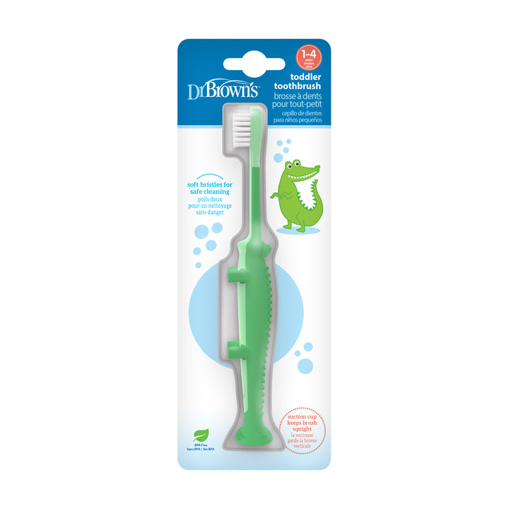 The Dr. Brown’s™ Toddler Toothbrush, Crocodile, 1-Pack is perfect for children aged 1-4. It comes with a fun crocodile-shaped green handle and a handy suction-cup base. The packaging emphasizes the super-soft bristles designed for safe cleaning and includes an adorable crocodile illustration for added playfulness.