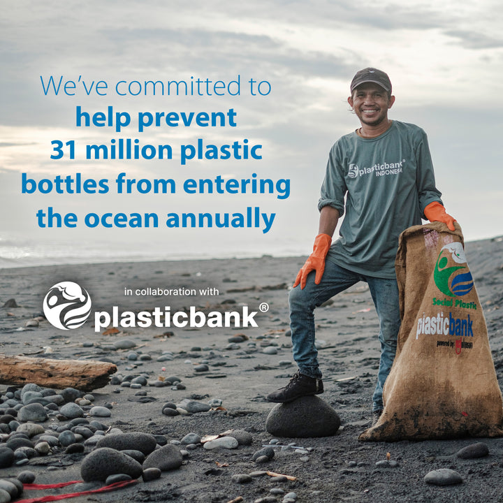 A smiling person stands on a rocky beach wearing a cap, gloves, and a Plastic Bank t-shirt, holding a large sack. Text states Dr. Brown’s commitment to prevent the equivalent of 31 million Dr. Brown’s Natural Flow® Anti-Colic Options+™ Narrow Baby Bottles with Level 1 Slow Flow Nipple from entering the ocean annually in collaboration with Plastic Bank.