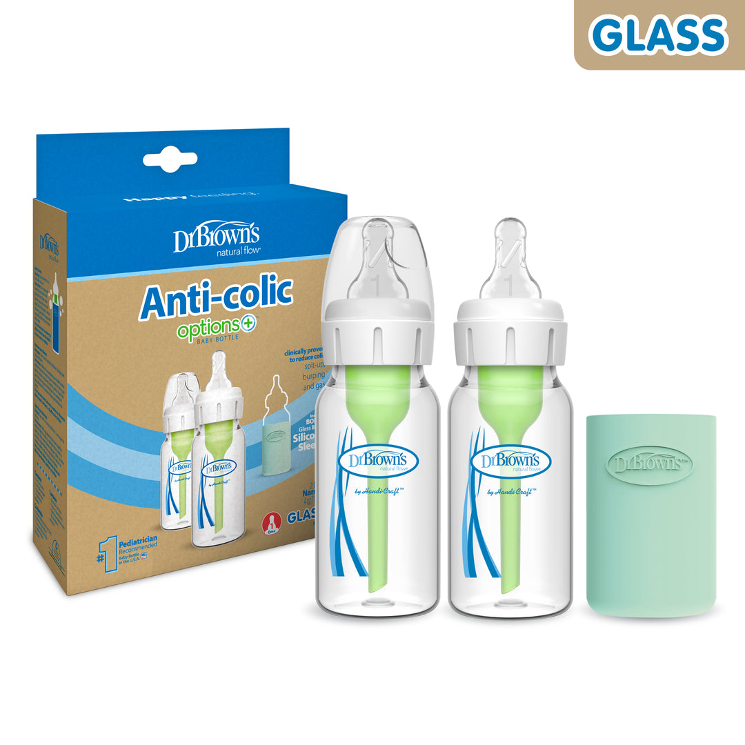 Displayed are the packaging and contents of the Dr. Brown’s Natural Flow® Anti-Colic Options+™ Narrow Glass Baby Bottle with Silicone Sleeve, 2-Pack by Dr. Brown's. The set includes two clear glass bottles with green anti-colic inserts, two breast-like silicone nipples, and a turquoise silicone sleeve. The box features labels "Anti-Colic Options+" and "GLASS.