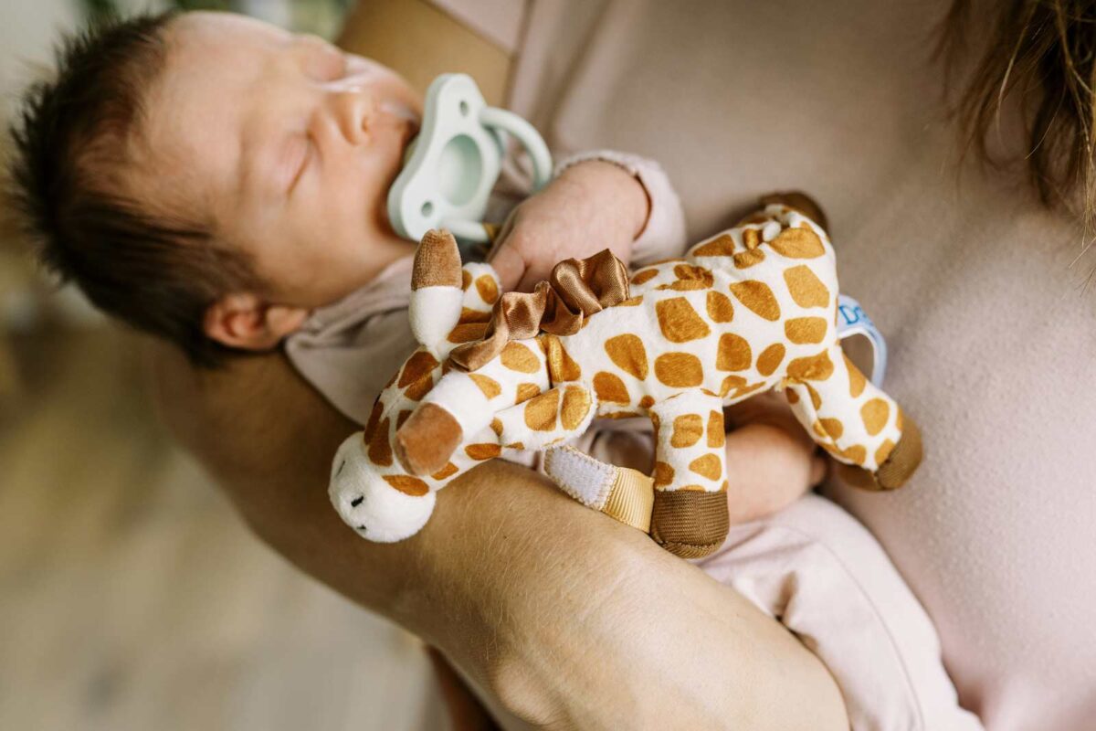 Baby with green HappyPaci and Giraffe Lovey